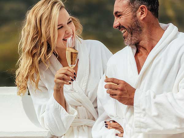 Couple Drinking Champagne In Bathrobes.