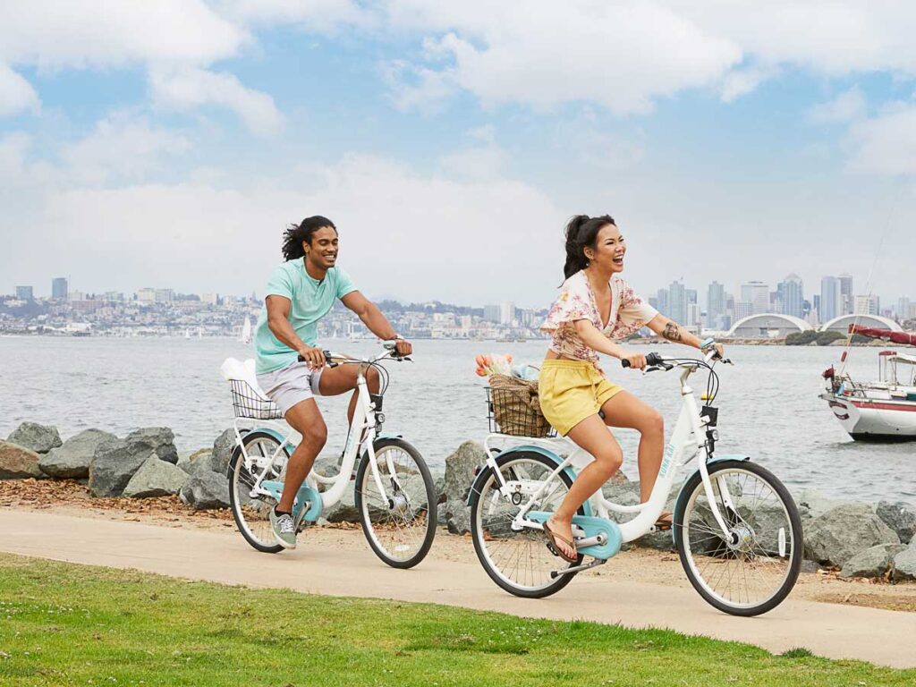 Couple Riding Bikes On The Beach.